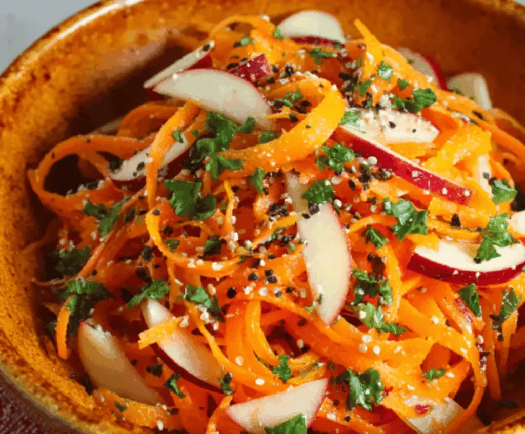 Colorful carrot and apple salad with fresh greens and nuts, perfect for a healthy snack or side dish