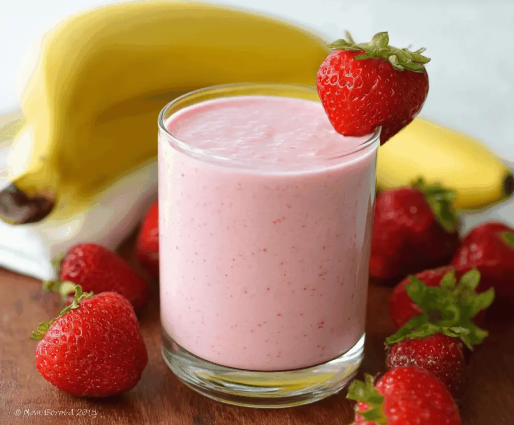 Refreshing strawberry banana smoothie in a glass with fresh strawberries and bananas, creamy and delicious drink perfect for breakfast.