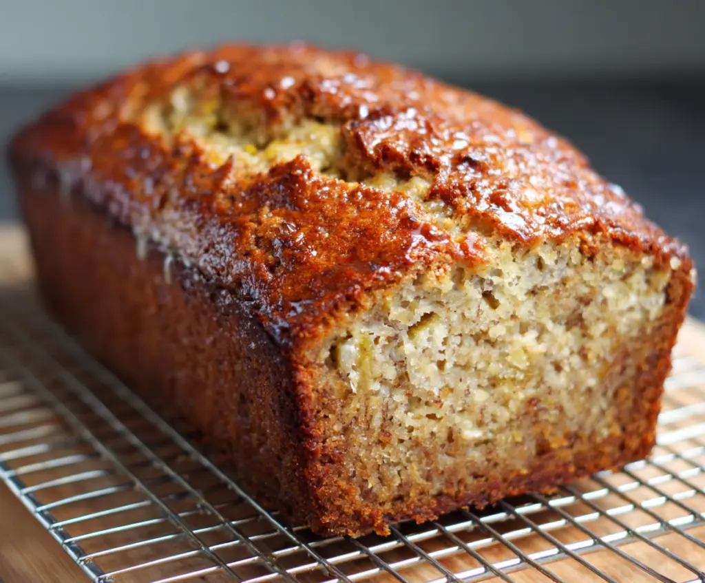 Delicious homemade Greek yogurt banana bread on a rustic wooden table, showcasing its moist texture and golden crust.