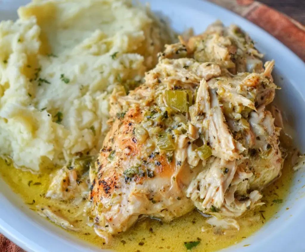 Creamy Slow Cooker Boursin Chicken served with fresh herbs and vegetables.
