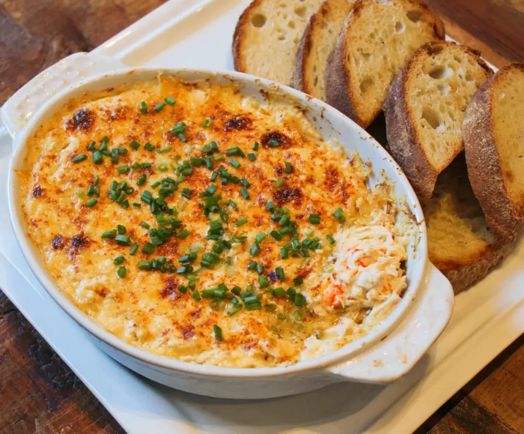 Delicious hot crab dip served in a bowl, garnished with herbs, perfect for appetizer or party snack